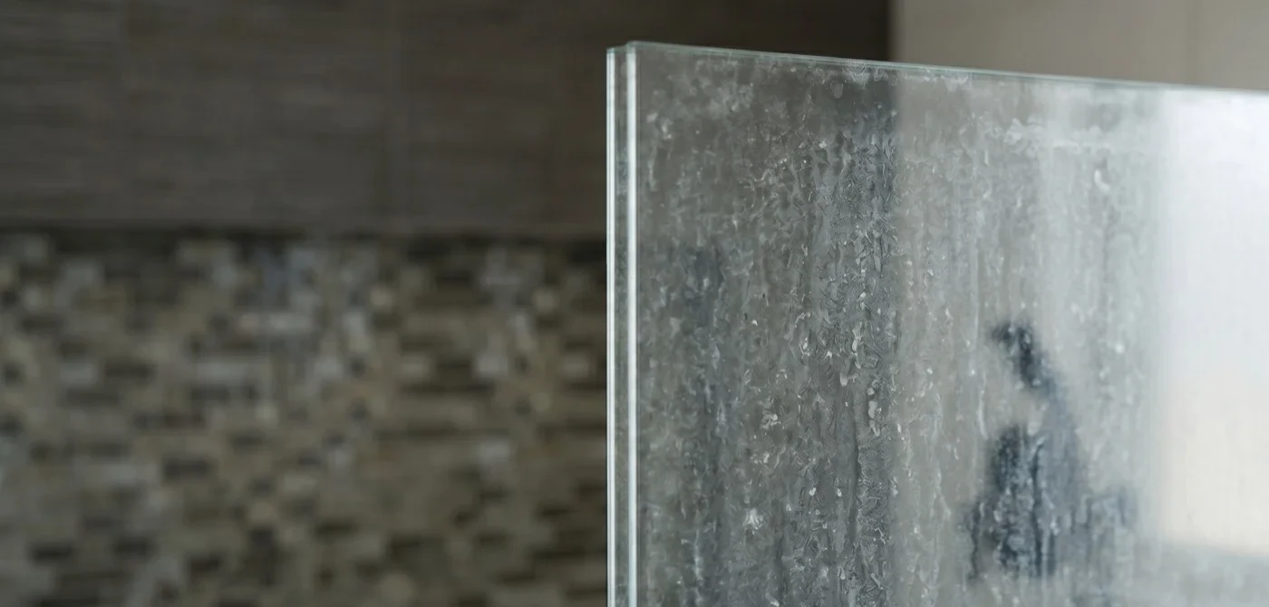 Shower glass with hard-water spots before treatment