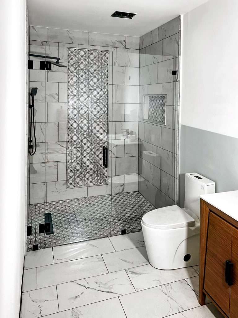 frameless glass shower door with enclosure. Black hardware and hinges.