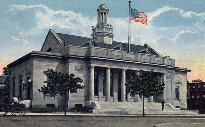 A historic building with columns and a central cupola in Beverly, MA, an American flag flying above, steps leading to the entrance, and trees and a lamppost in front. A person stands on the steps and a horse-drawn carriage is visible.