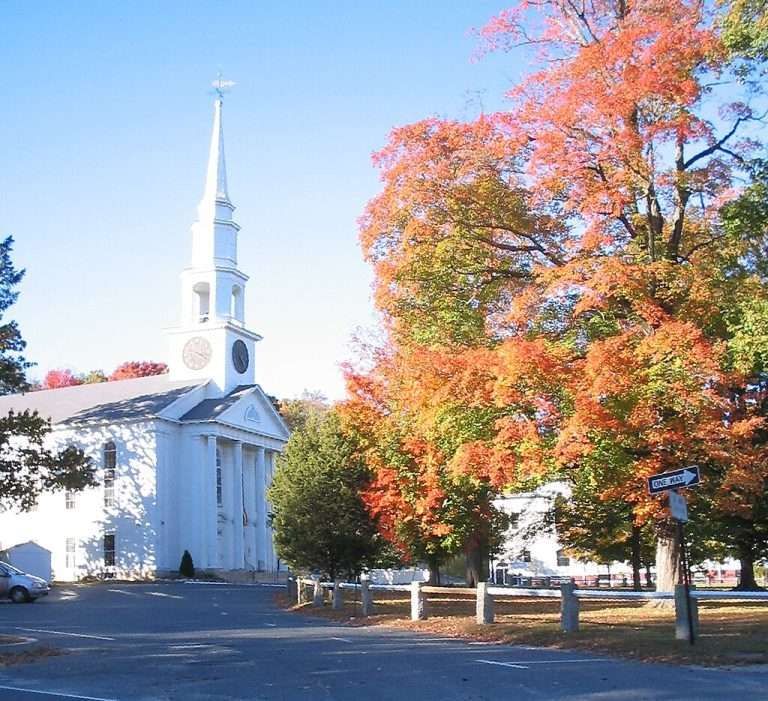 White church beside colorful autumn trees