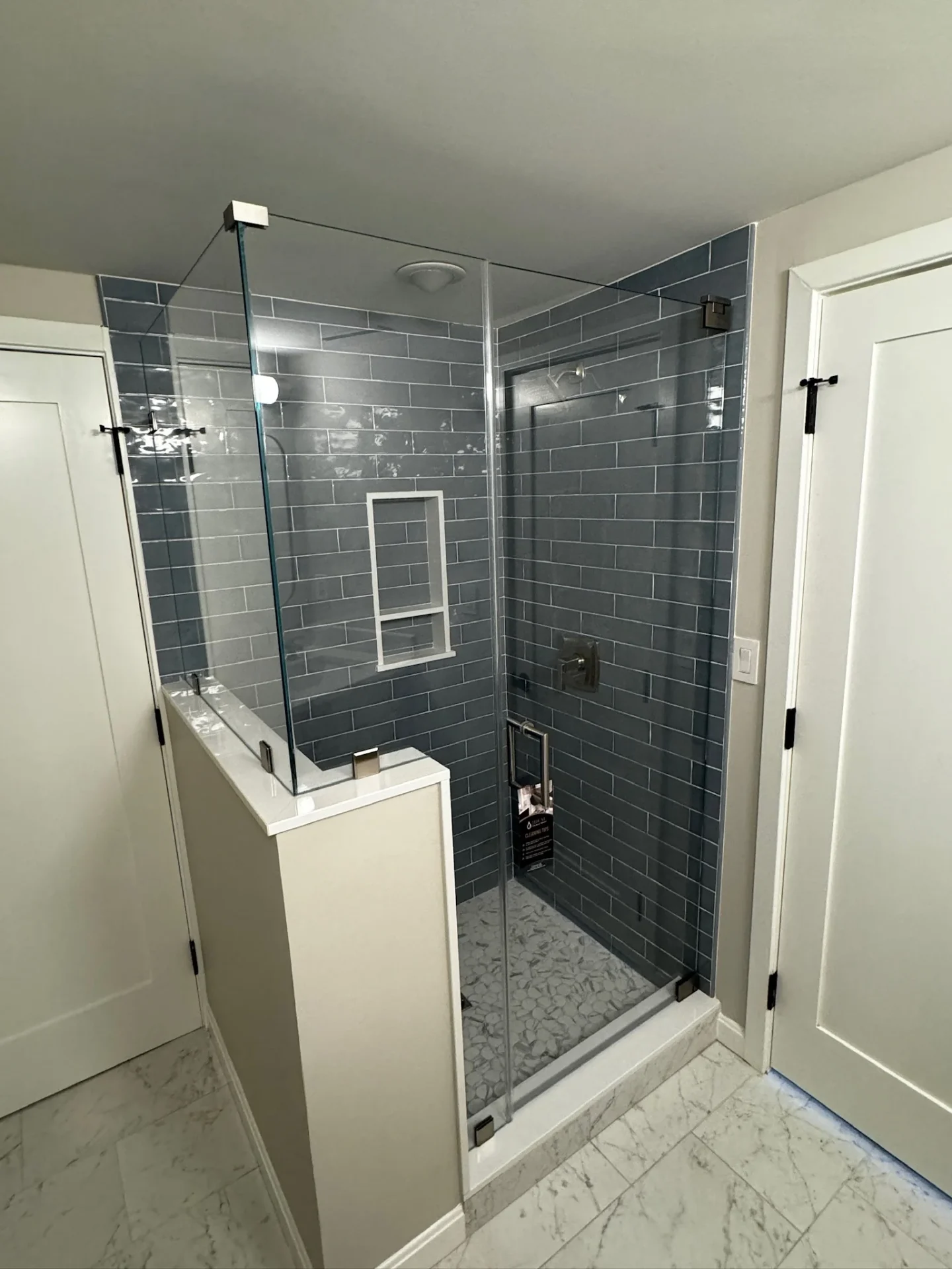 frameless pivot shower door matte black blue subway tile Beverly MA