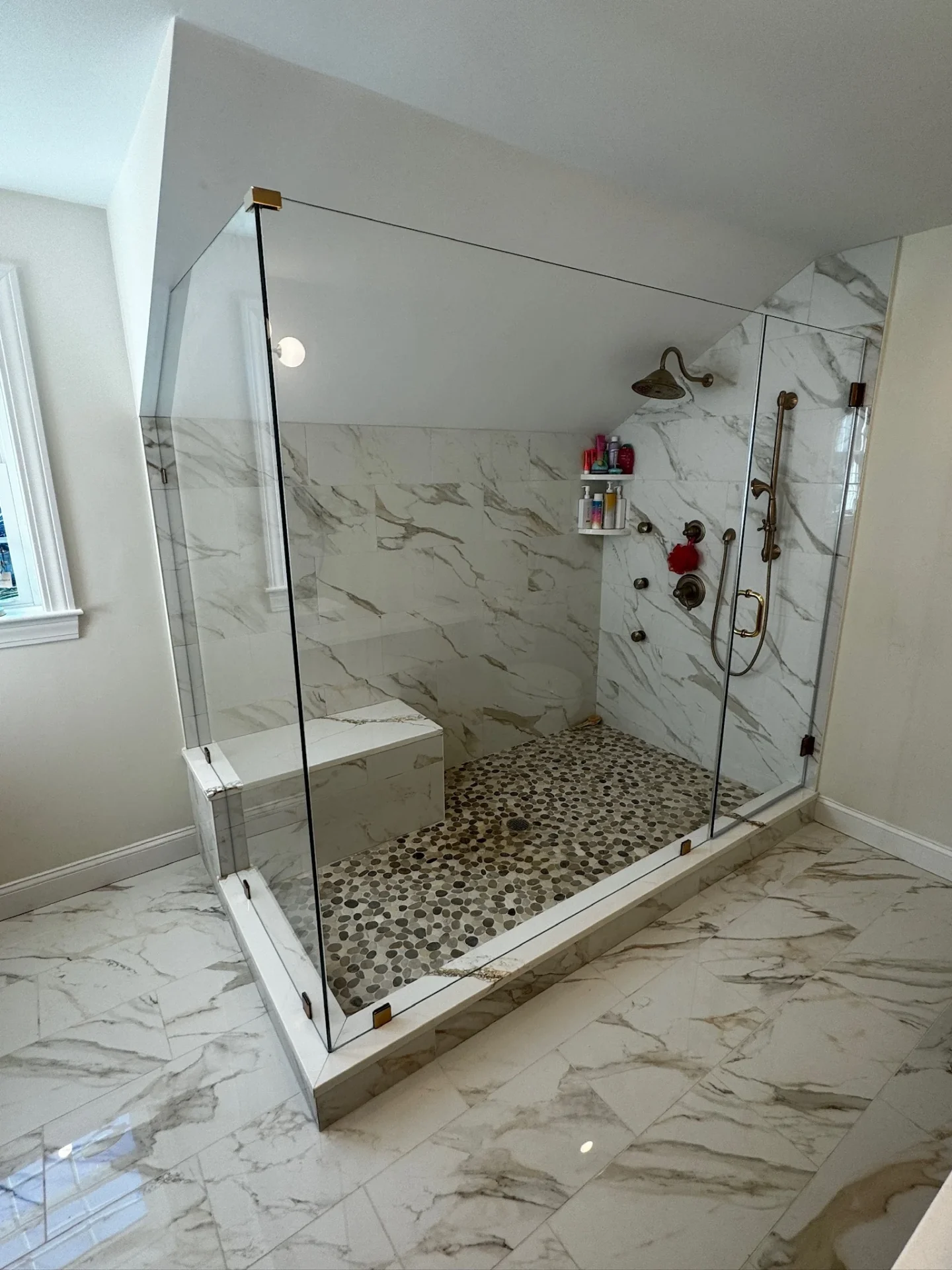 frameless hinged glass shower enclosure brass hardware marble tile Lynnfield MA