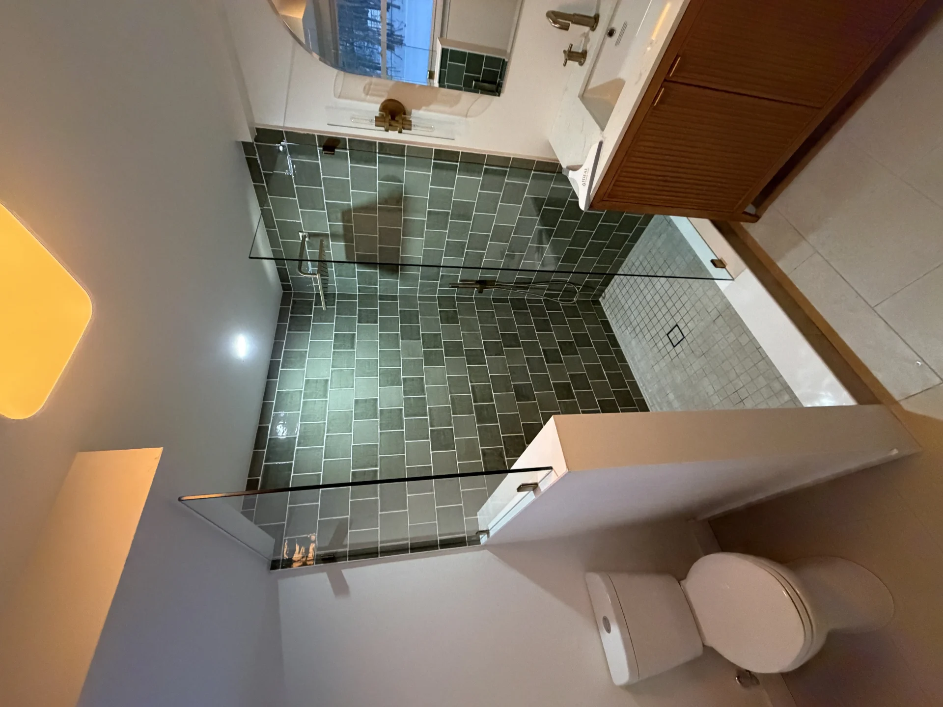frameless glass panel walk-in shower green subway tile brass hardware Chelmsford MA