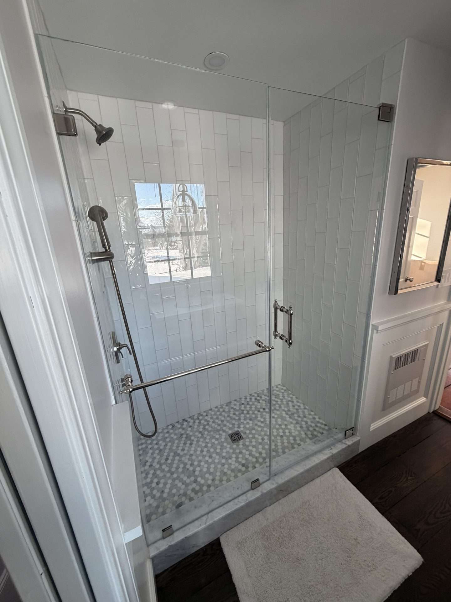 Frameless shower door with white subway tile, hexagon mosaic floor, polished chrome hardware, Chelmsford MA