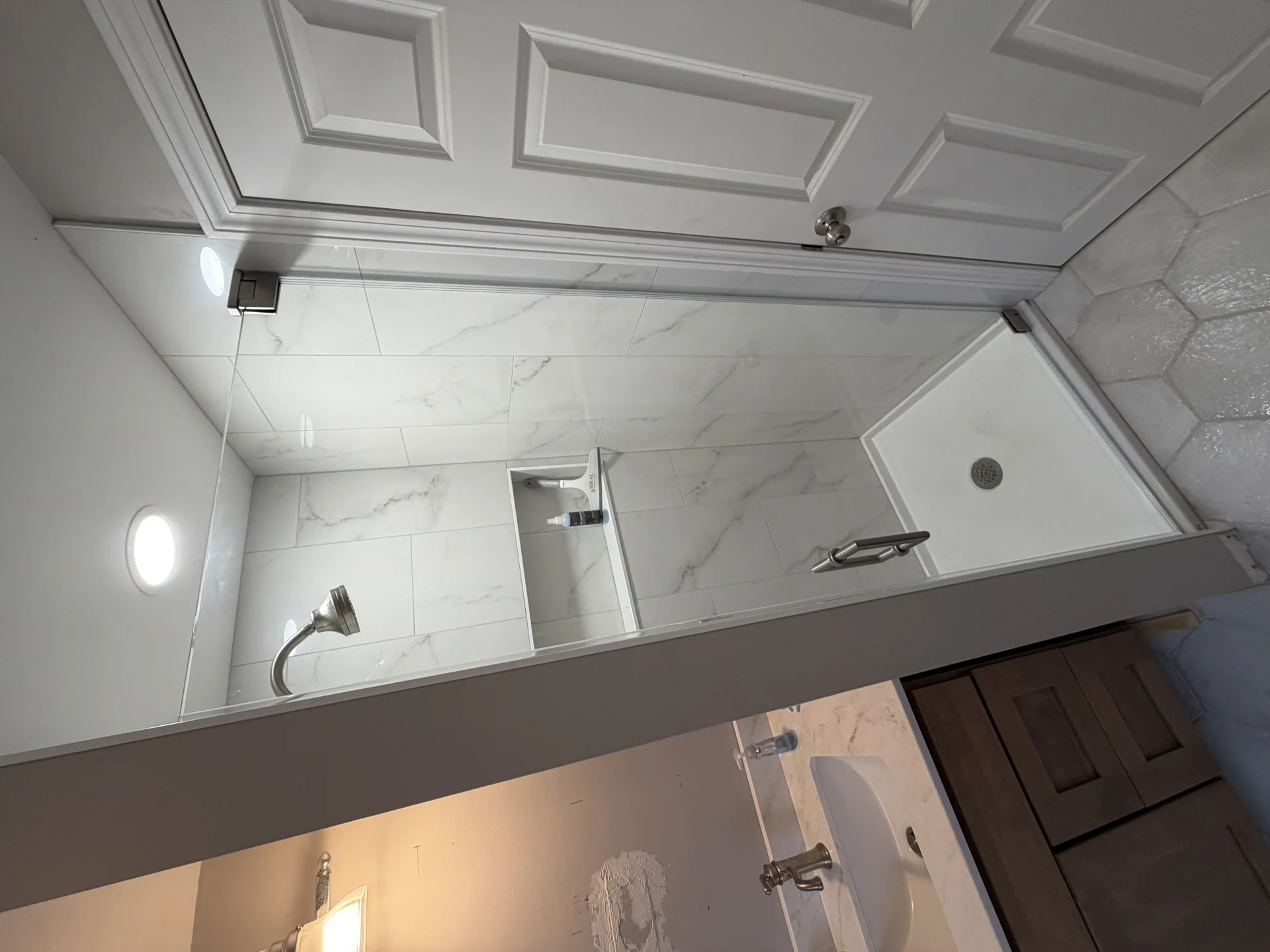 Frameless pivot door brushed nickel large-format marble porcelain tile Boston MA