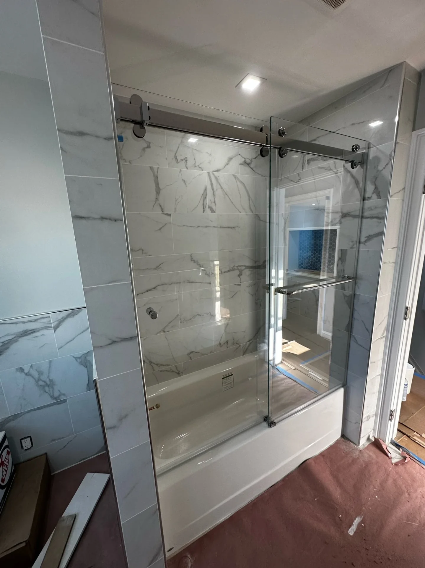Frameless sliding tub enclosure polished chrome Calacatta marble tile Boston MA