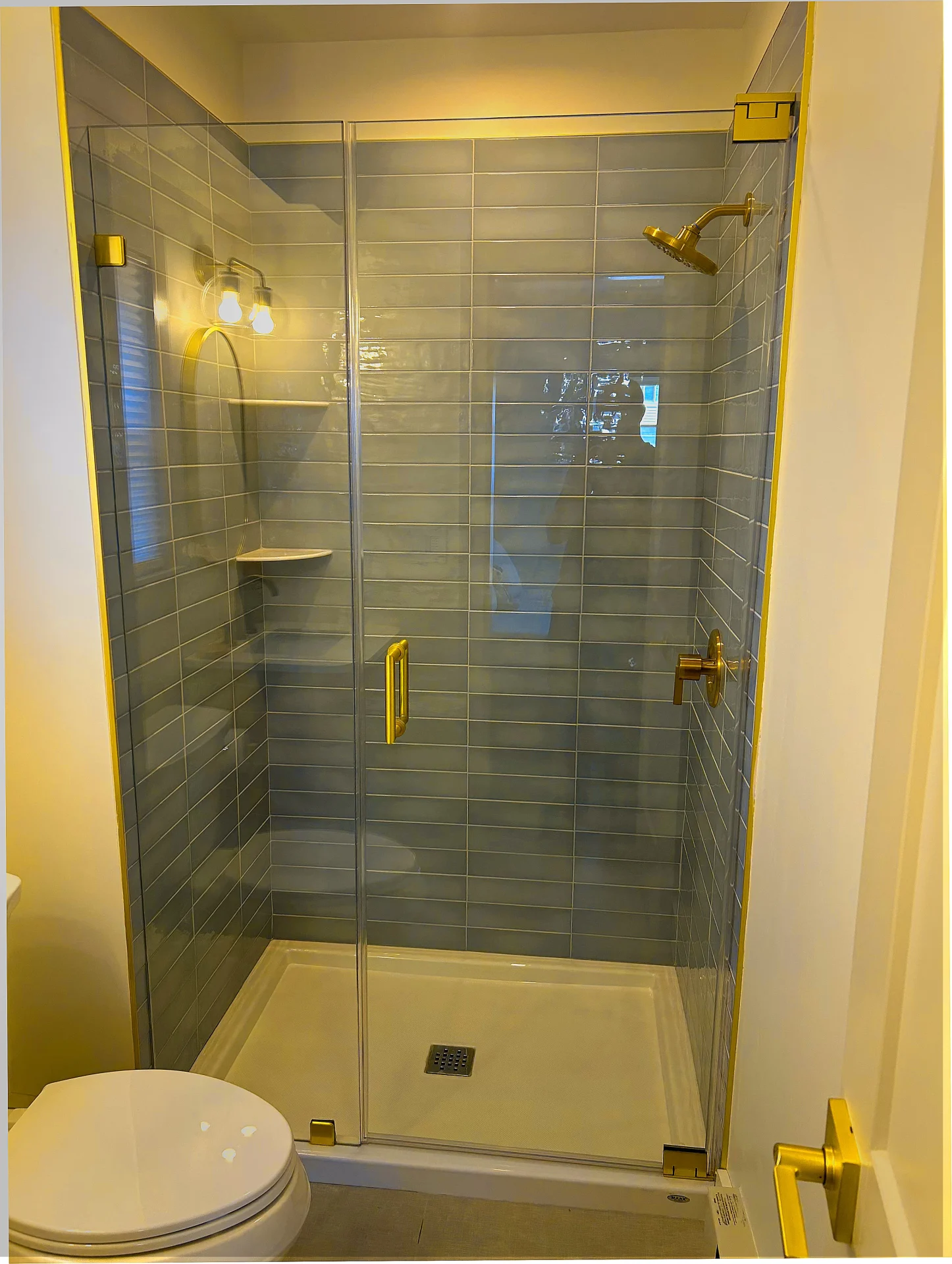 Frameless pivot door brushed gold slate blue subway tile Swampscott MA