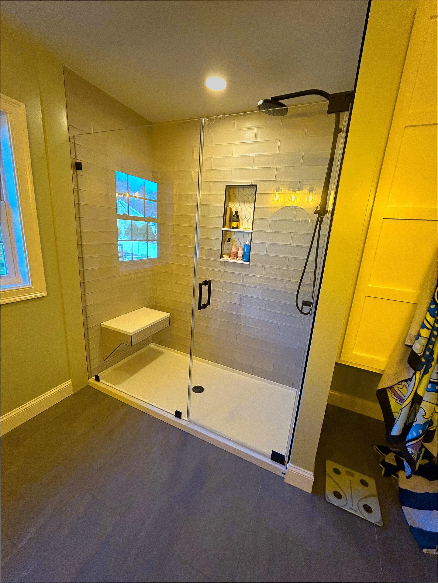 Frameless hinged shower door matte black hardware gray subway tile Merrimac MA