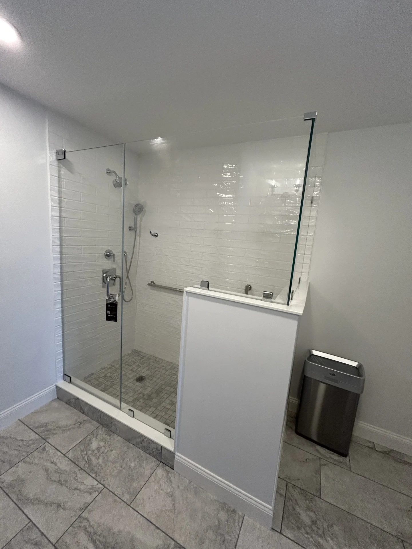Frameless hinged shower door chrome half-wall white subway tile Milton MA