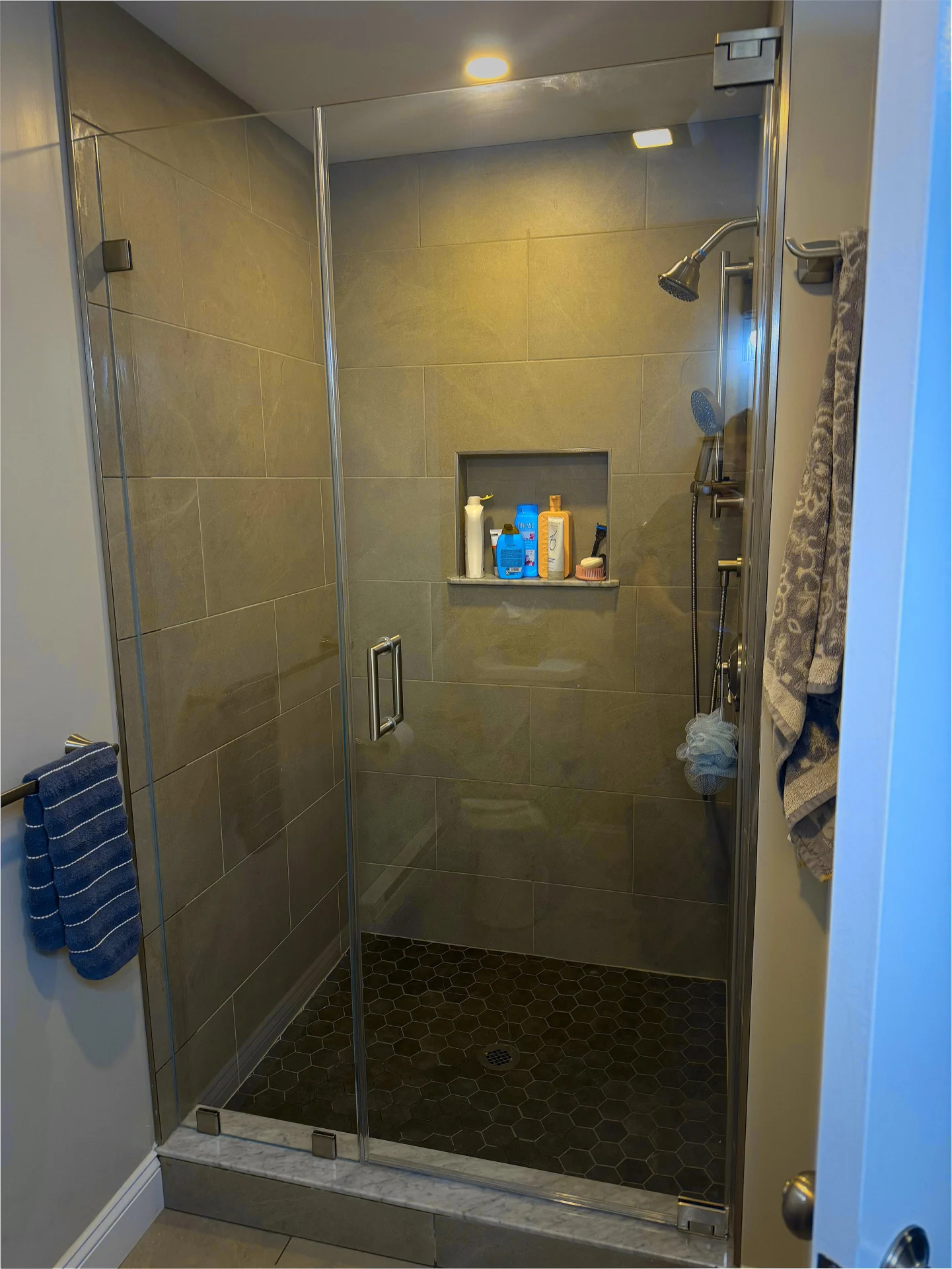 Frameless pivot door brushed nickel charcoal porcelain pebble floor Danvers MA