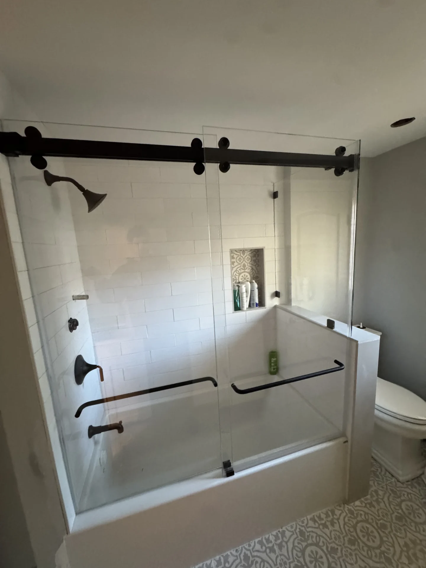 Frameless bypass sliding tub door matte black track subway tile Andover MA