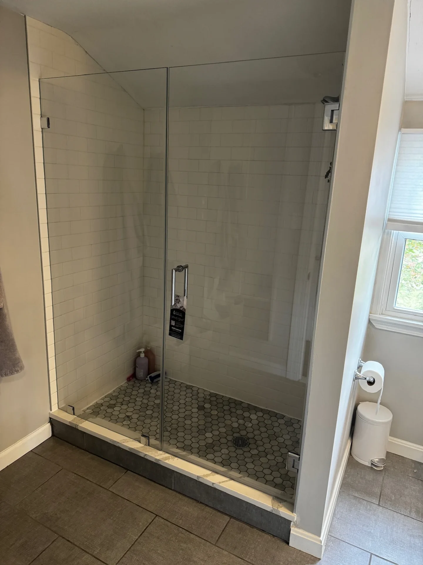 Frameless inline shower door chrome hinges sloped ceiling subway tile Wilmington MA