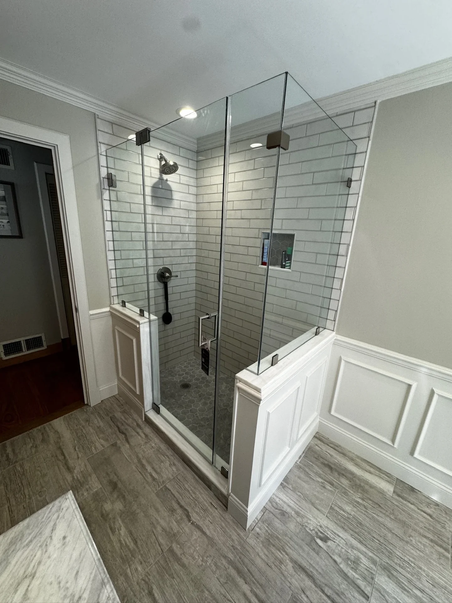 Frameless corner shower enclosure matte black hardware subway tile Stoneham MA