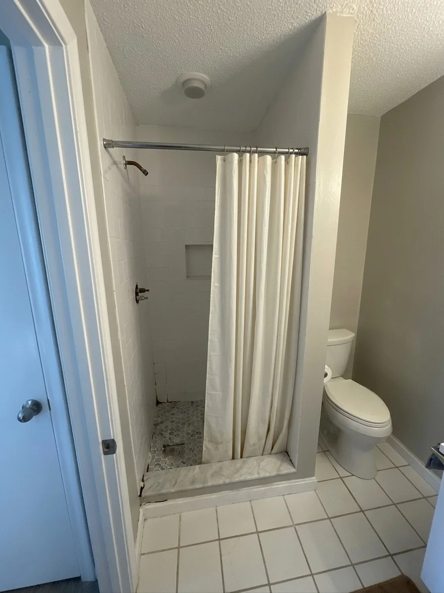 Before photo of alcove shower with fabric curtain and white subway tile in Wellesley MA bathroom