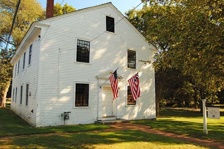 Historic white meeting house with American flags