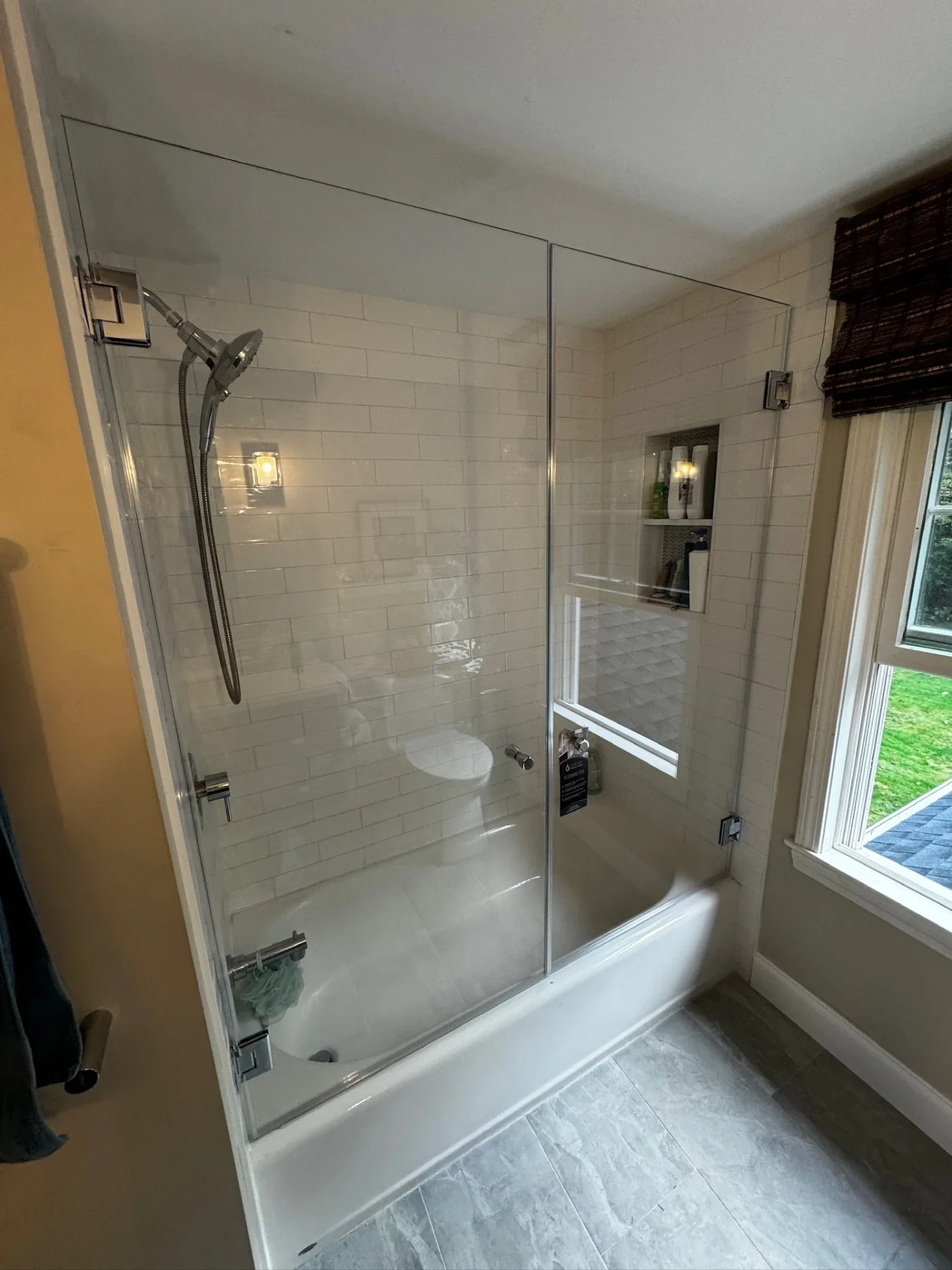 Frameless tub enclosure chrome hardware white subway tile Rowley MA