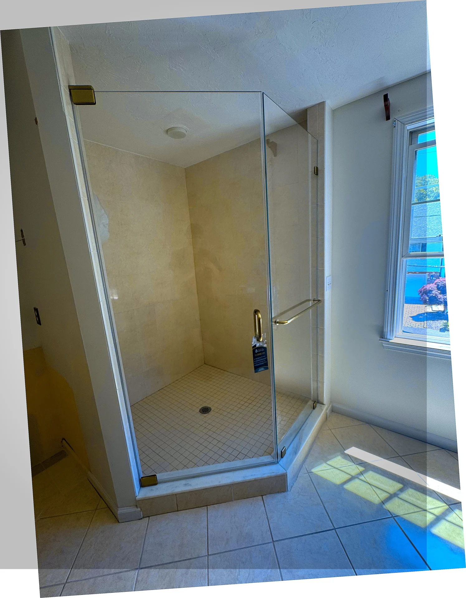 Frameless pivot door brass hardware cream tile Needham MA