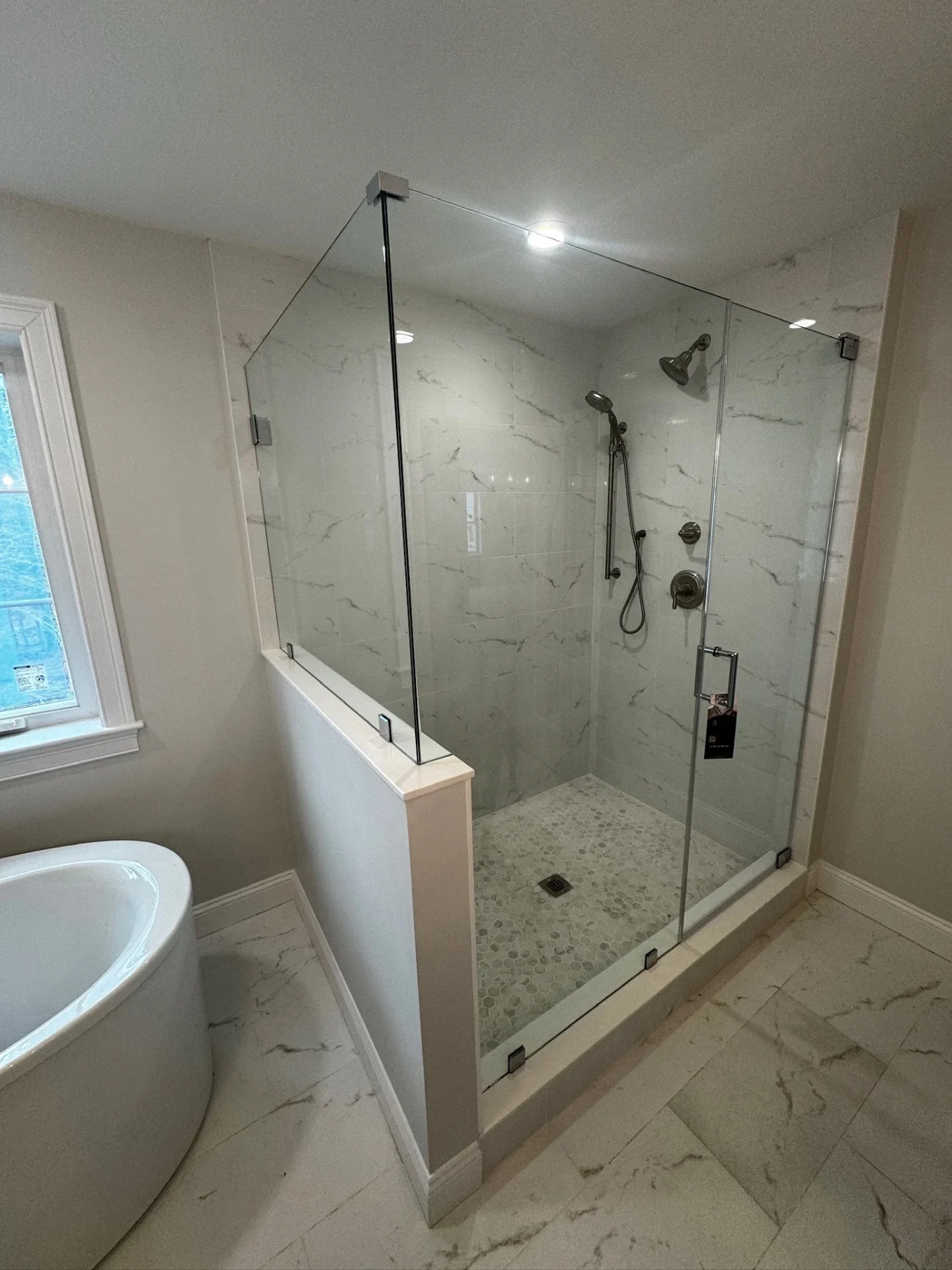 Frameless knee-wall enclosure brushed nickel marble tile freestanding tub Rowley MA