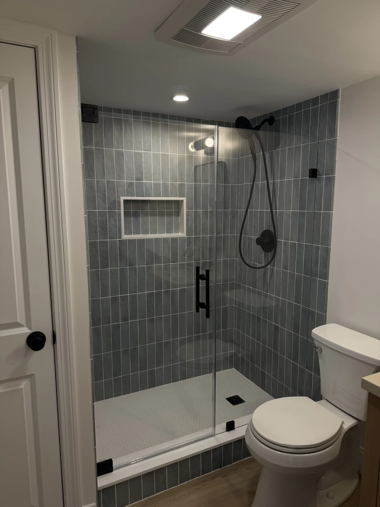 Frameless shower matte black hardware vertical blue gray tile Reading MA