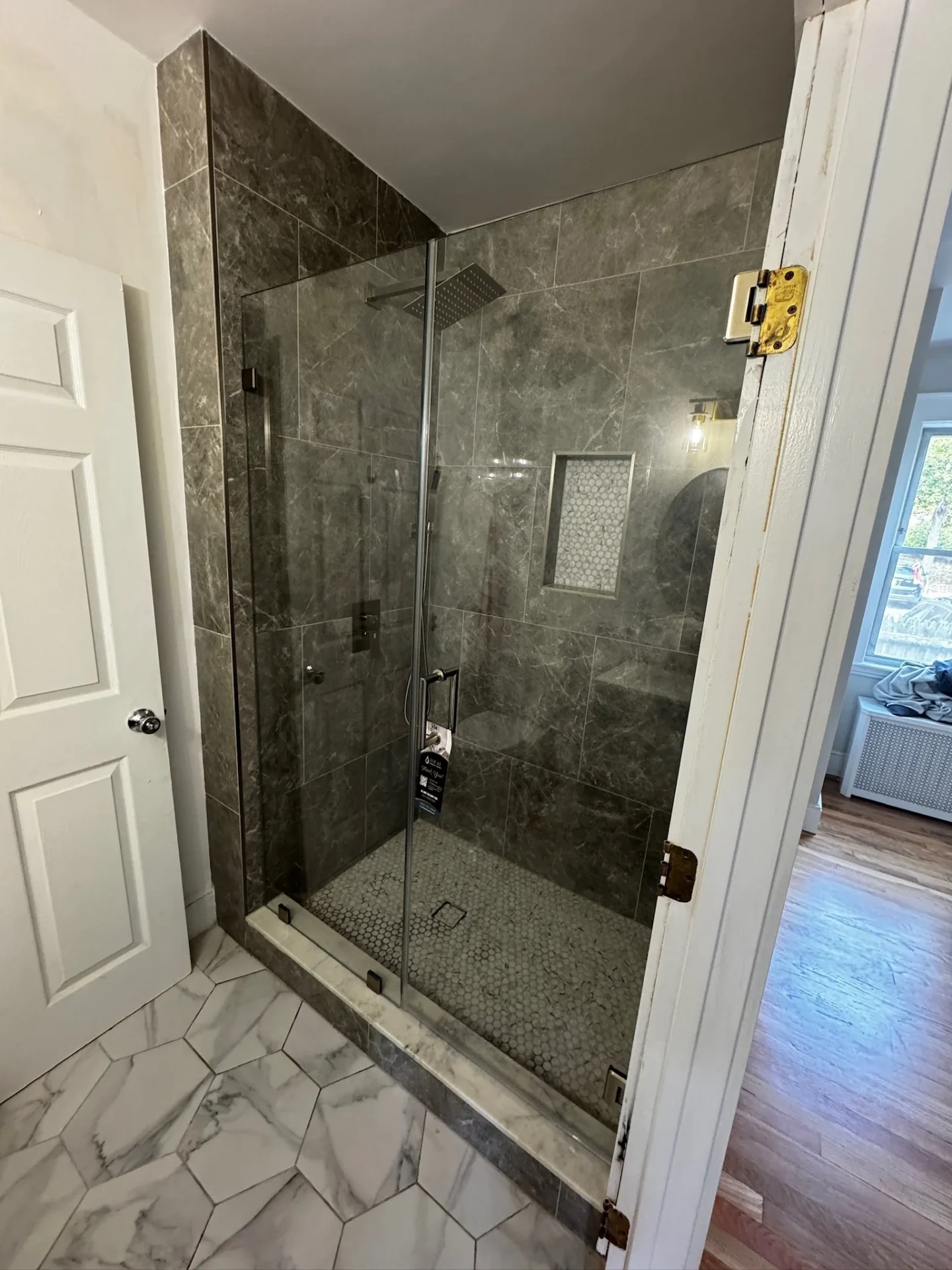 frameless pivot door brushed nickel dark marble tile penny tile floor Quincy MA