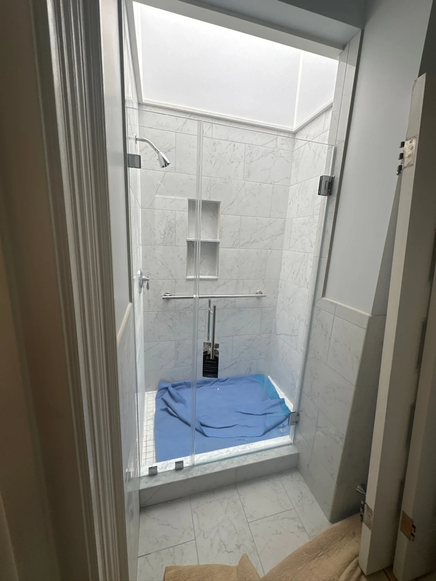 frameless pivot shower door chrome hardware Carrara marble tile Newburyport MA