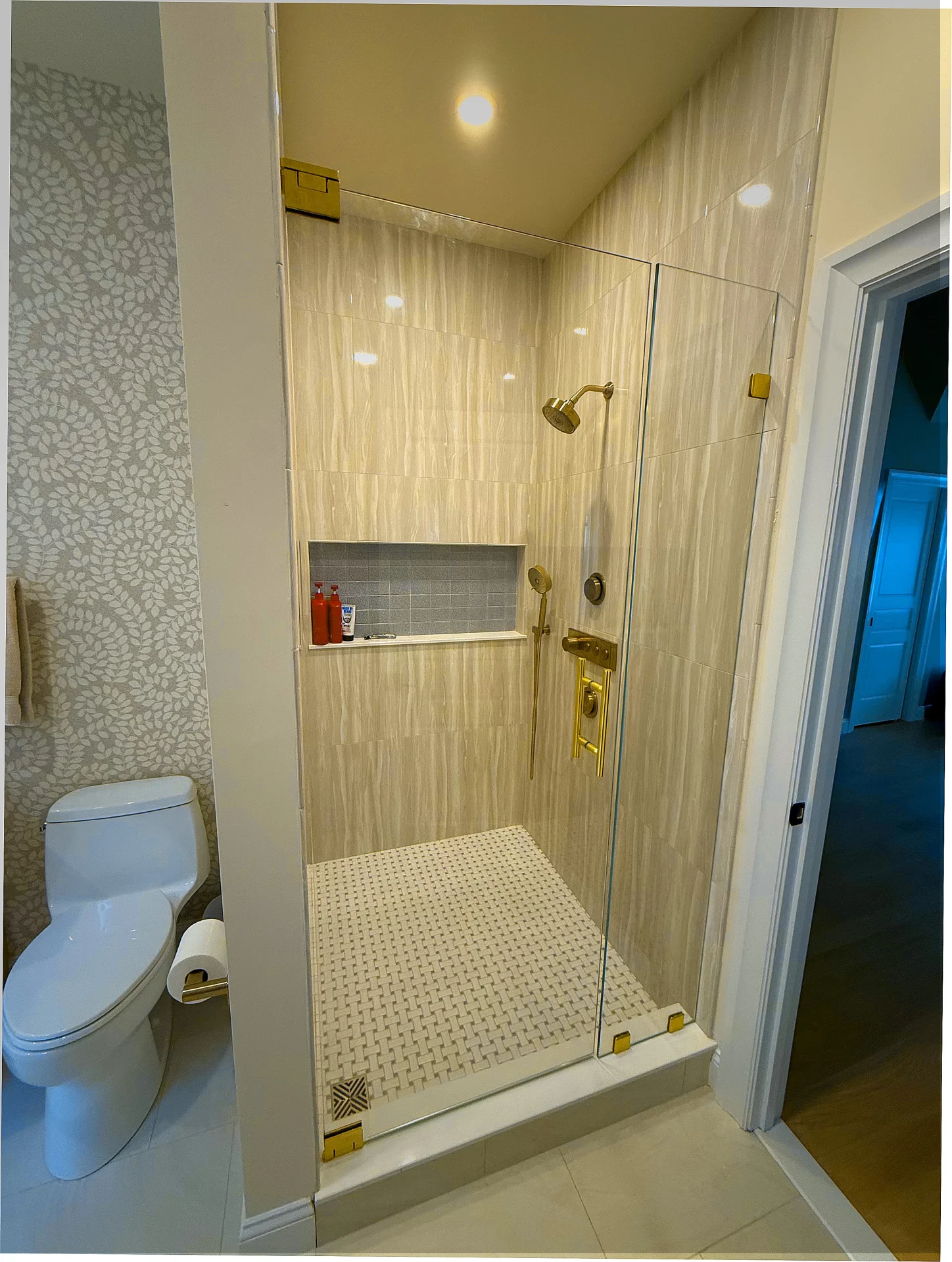Frameless single pivot door brushed gold hardware wave tile Bedford MA