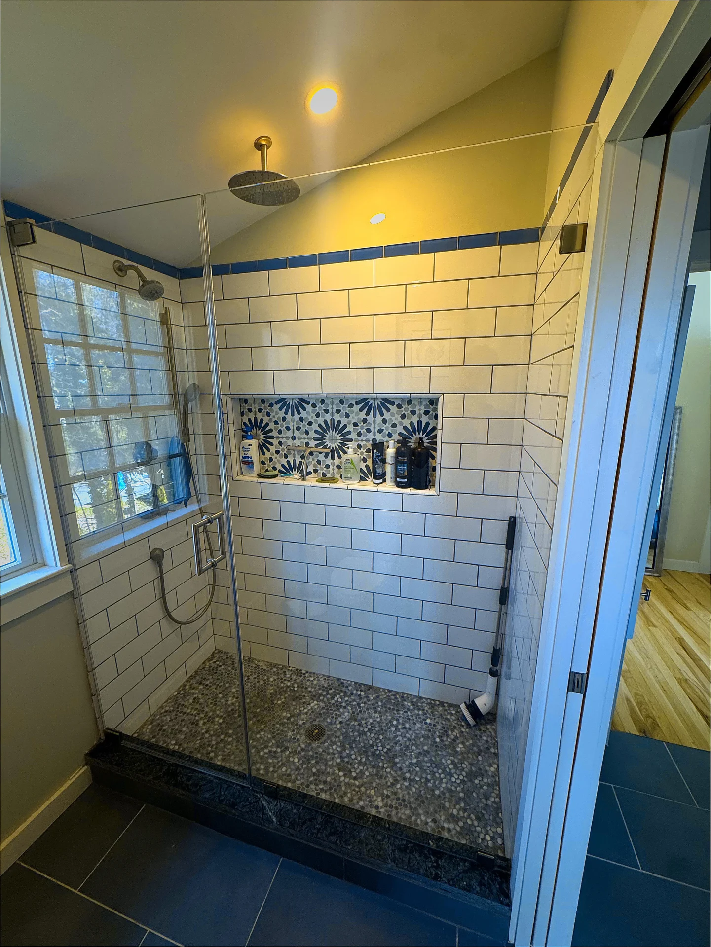 Frameless walk-in panels matte black hardware subway tile pebble floor Beverly MA