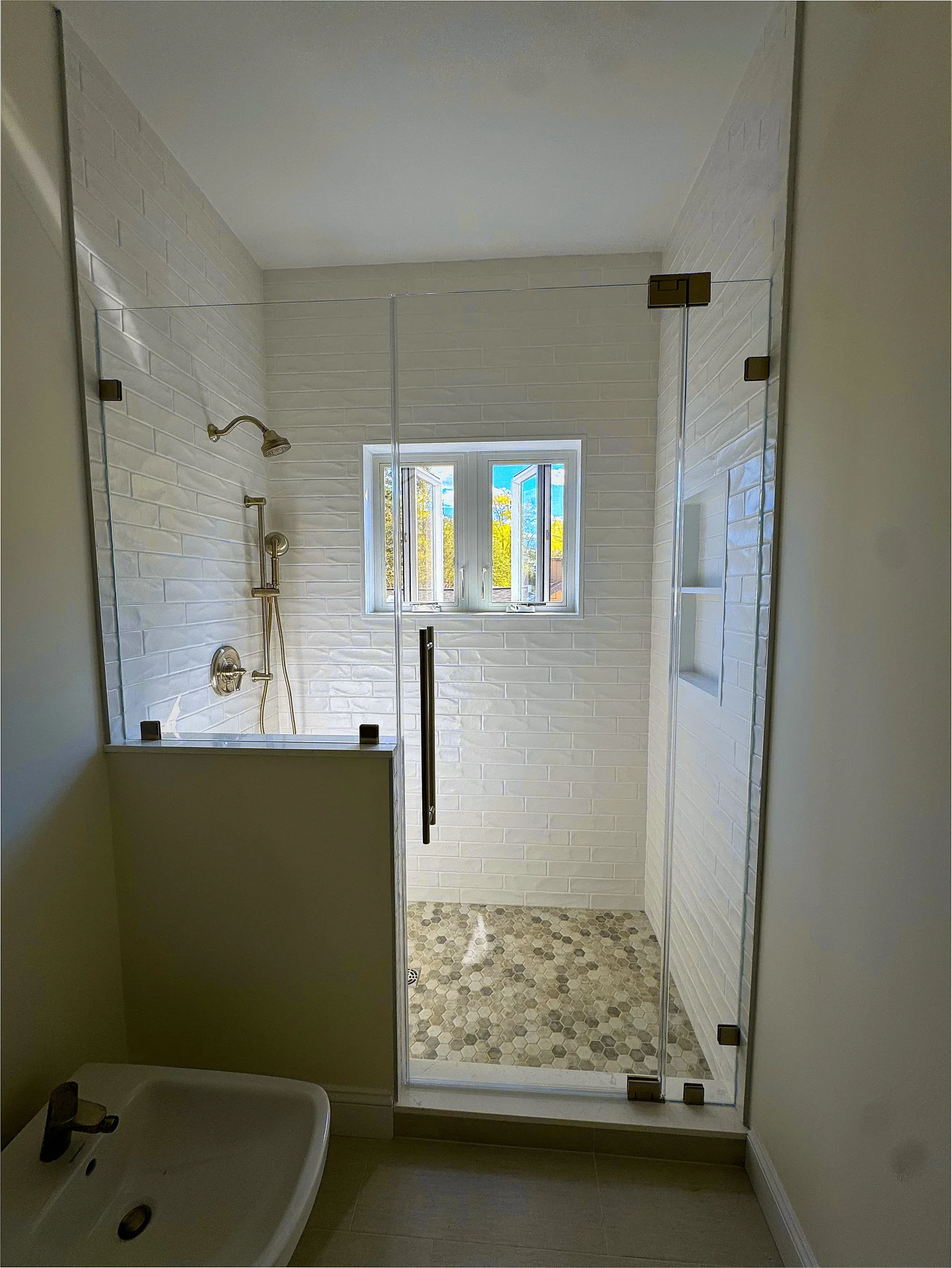 frameless pivot shower door dark bronze hardware subway tile Windham NH