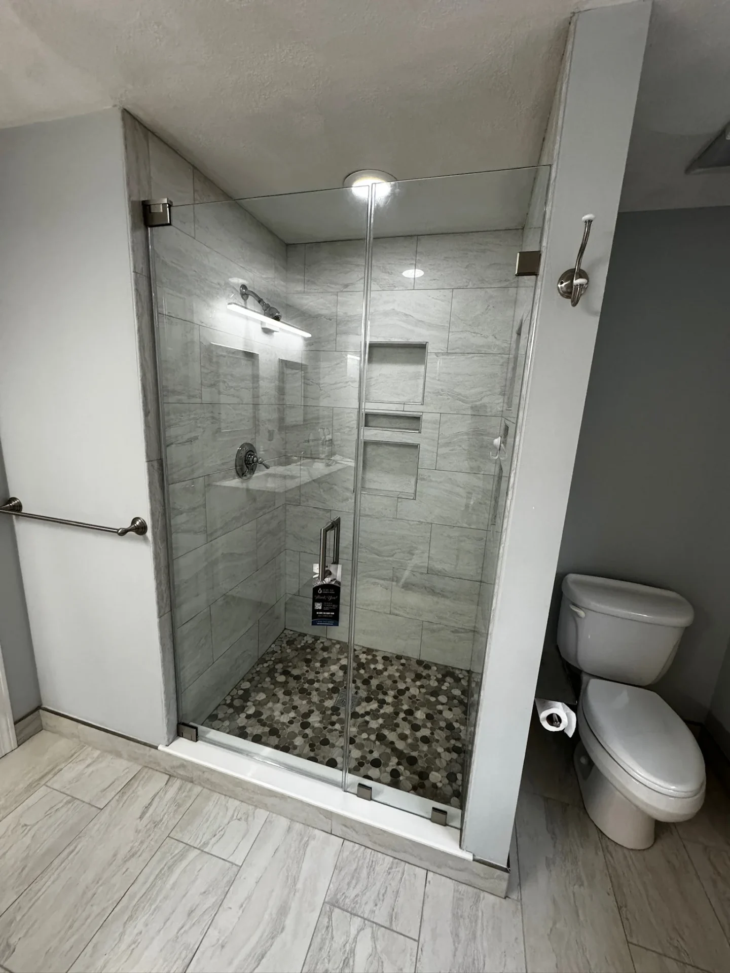 Frameless inline pivot door brushed nickel marble tile Groveland MA