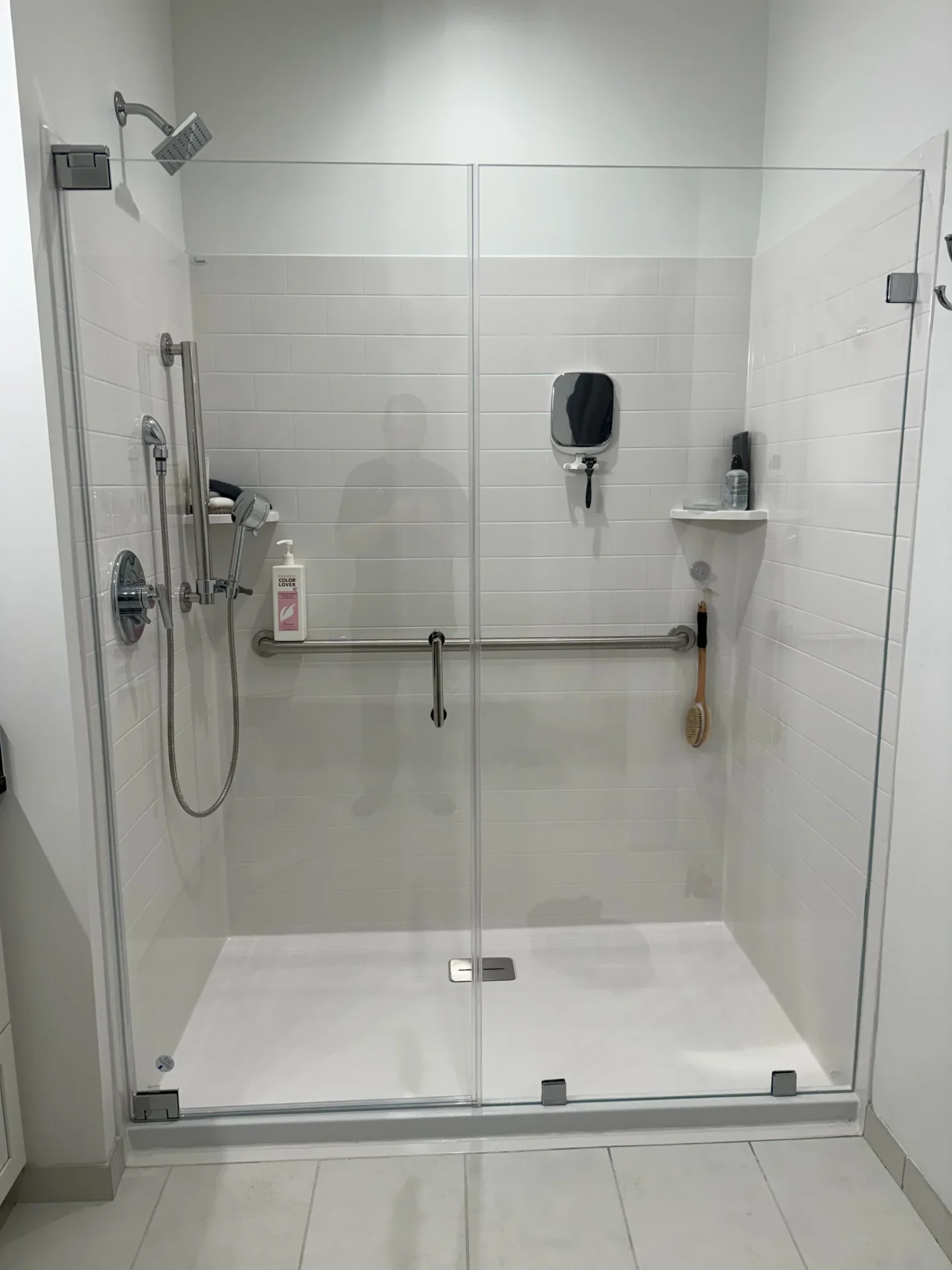 Frameless swing shower door with brushed nickel grab bar in Newton MA