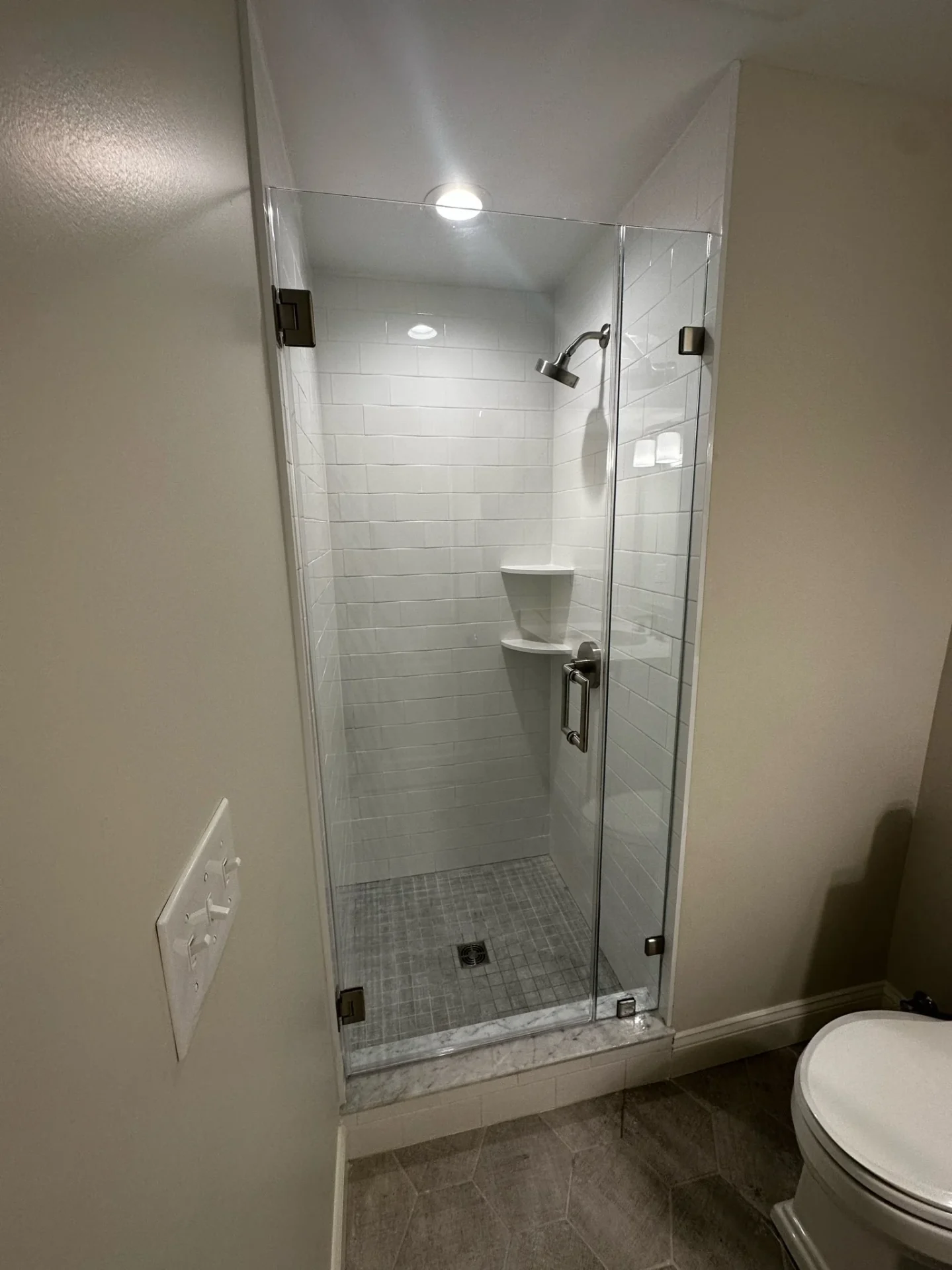 Frameless pivot shower door with satin nickel hinges in Reading MA