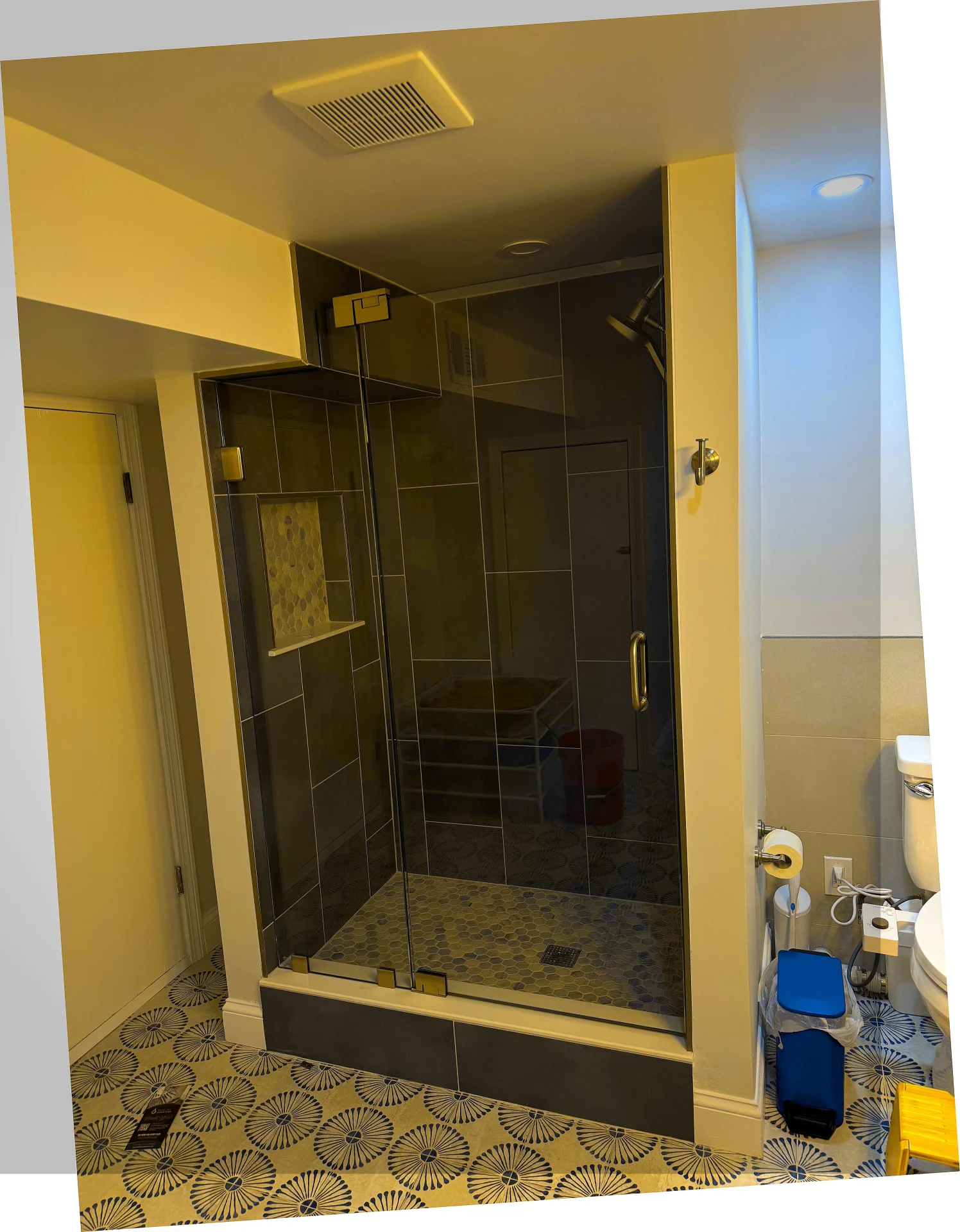 Frameless shower door with brass hardware and mosaic tile in Holbrook MA