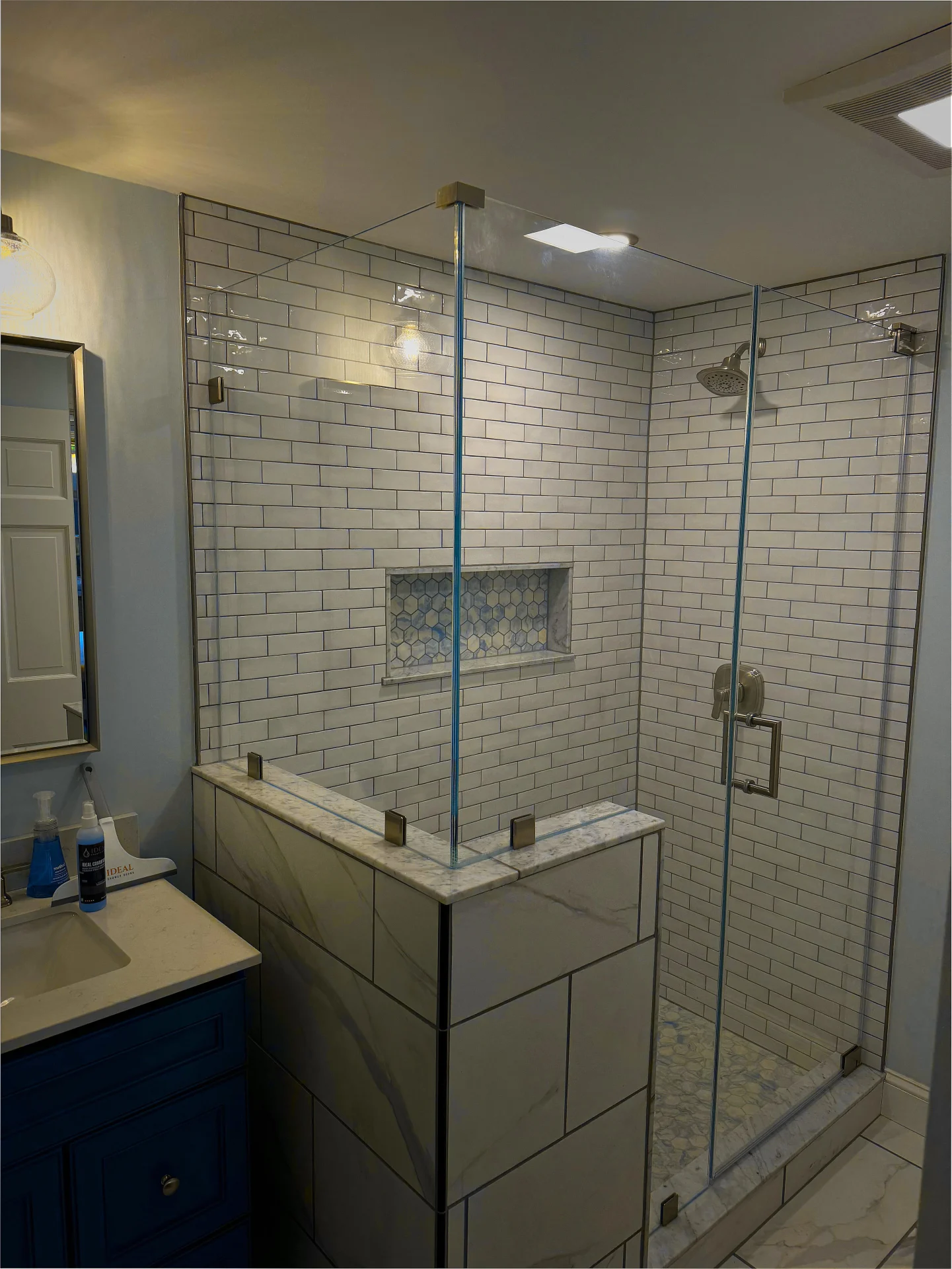 Frameless corner shower door, brushed nickel hardware, marble mosaic niche, Bedford NH