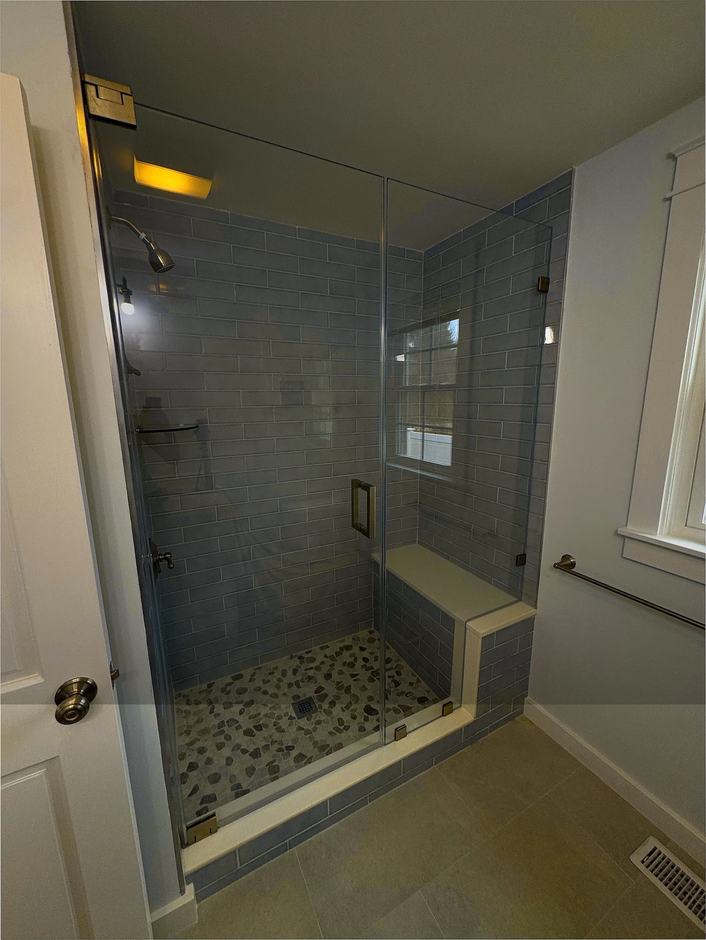 Frameless hinged shower door, bronze hardware, blue subway tile, North Reading MA