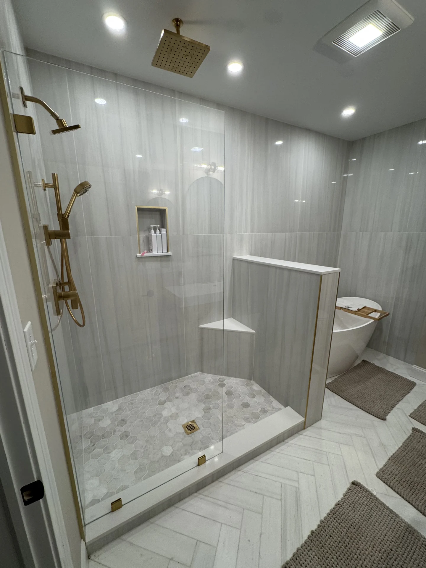 Neo-angle shower door with brushed gold hardware and corner seat in Danvers MA
