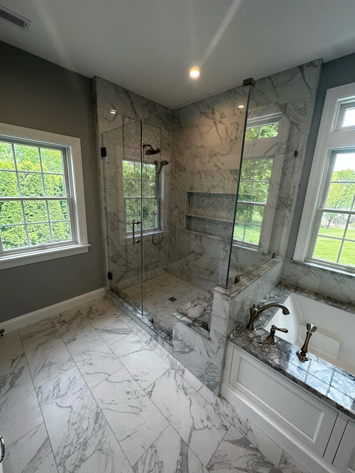 Frameless corner shower enclosure on marble slab, brushed nickel, North Andover MA