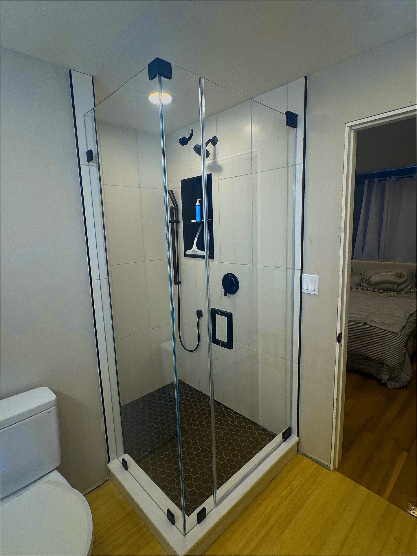 Frameless corner shower enclosure with matte black hardware and hexagon floor, Peabody
