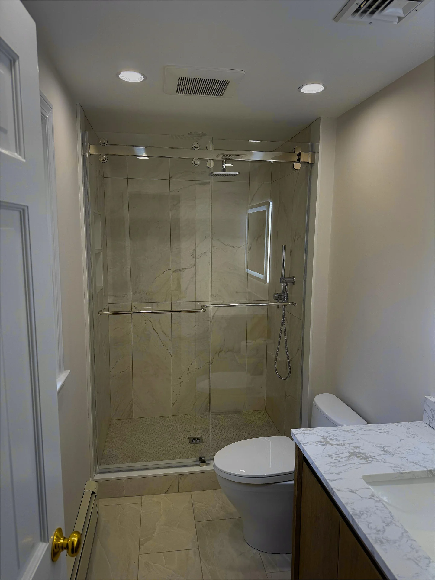 Frameless sliding shower door, polished nickel hardware, marble tile, Lynnfield MA