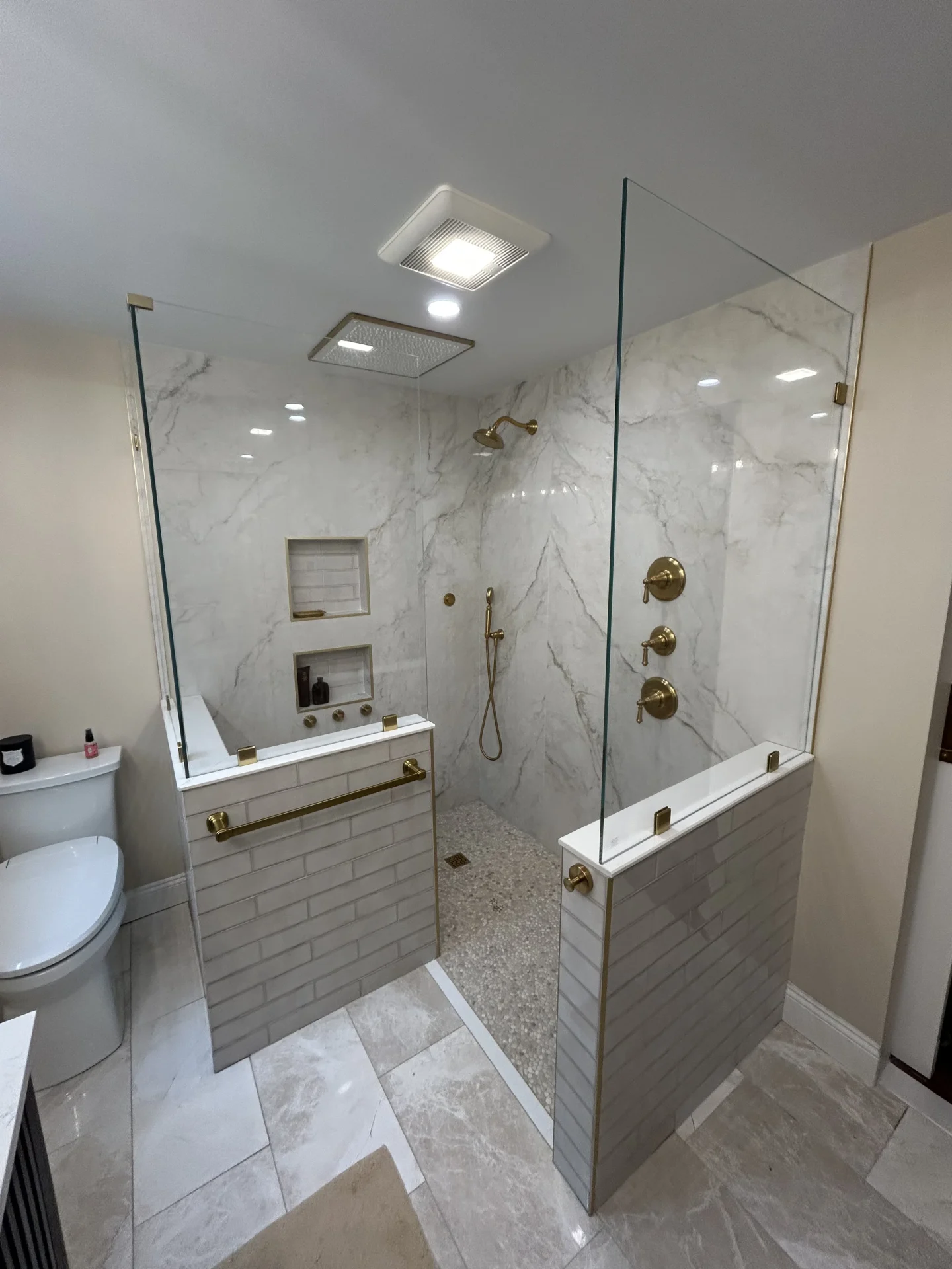 Curbless walk-in frameless shower, champagne bronze hardware, marble, Sudbury MA