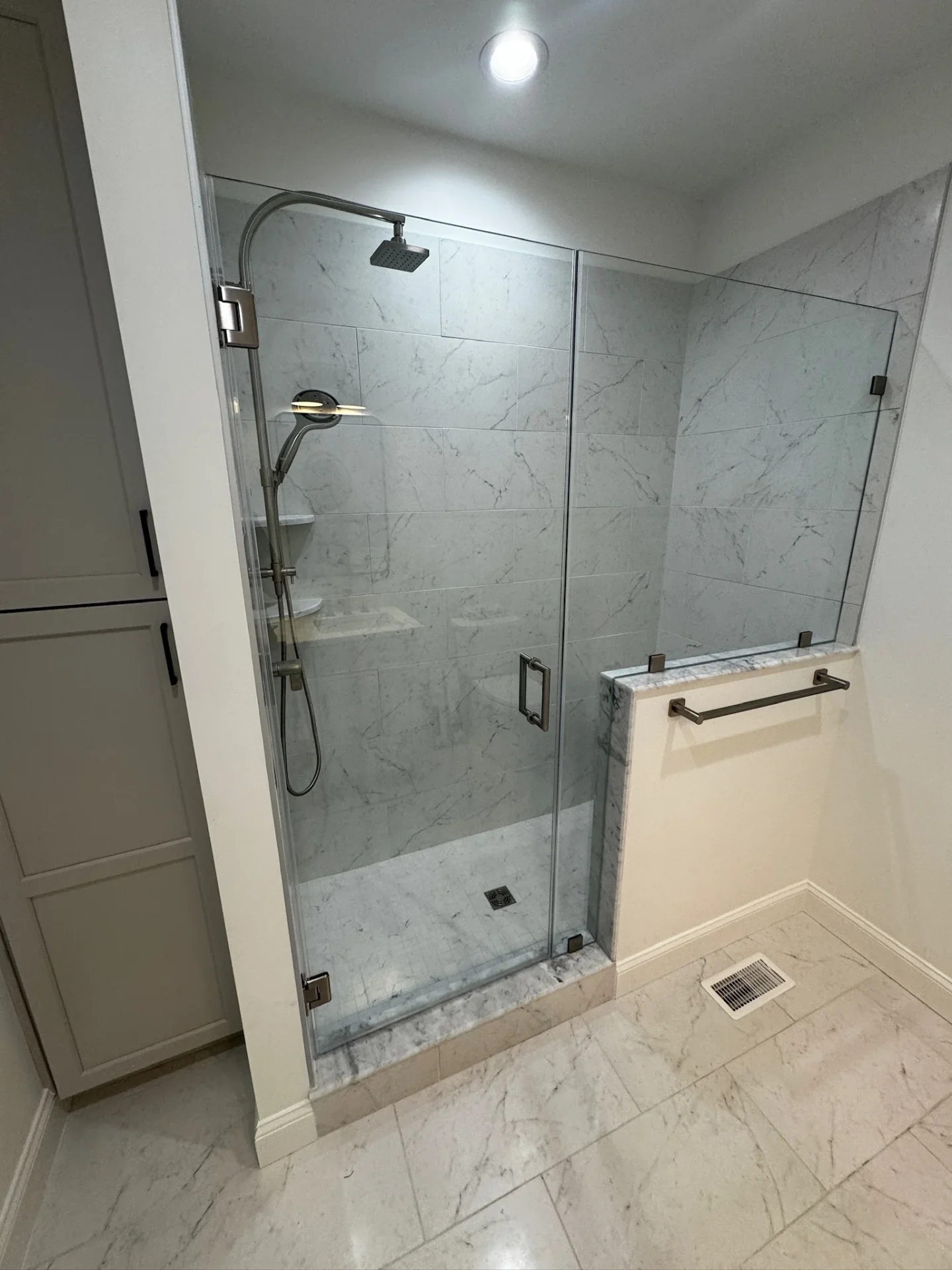 Frameless pivot shower door, brushed nickel hardware, marble bench, Reading MA